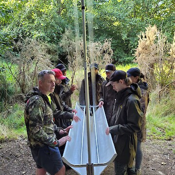 Ian explaining how to set up the Harp traps. The tauira helping to put these together and place them.
