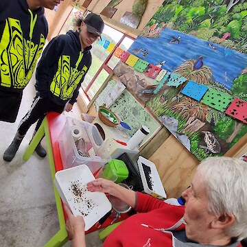 Chris Rance showing tauira the process of drying seeds.