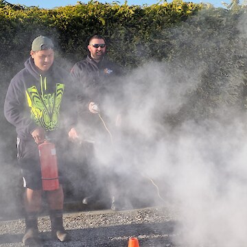 Kaloni Taylor using the CO2 extinguisher under the supervision of Daniel Munro (from PWFP Fire Safety).